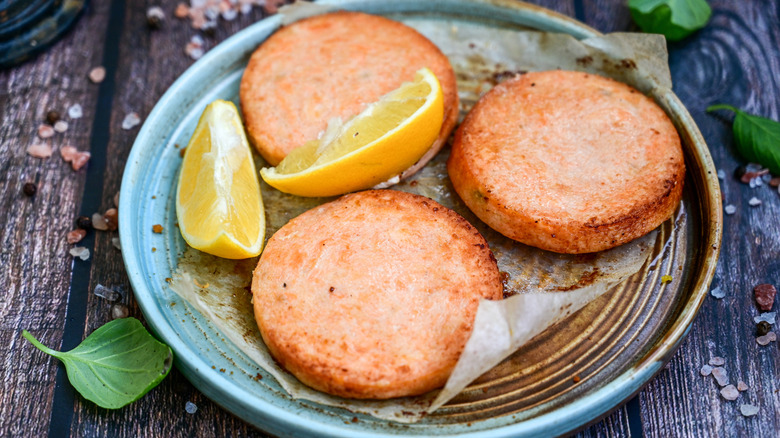 Salmon patties with lemon wedges