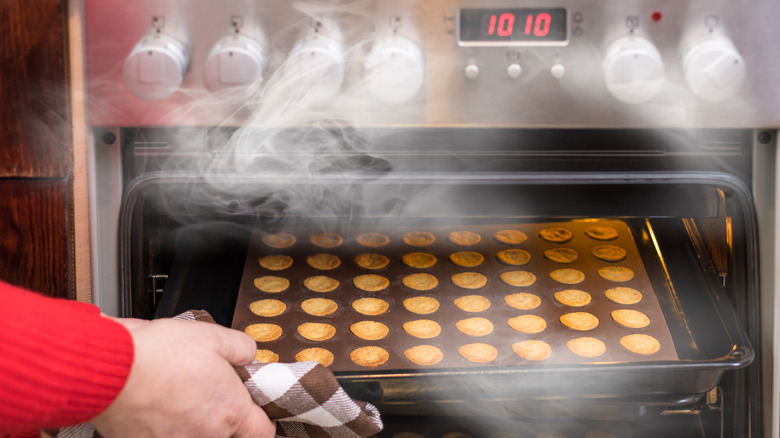 Person pulling tray of cookies from convection oven