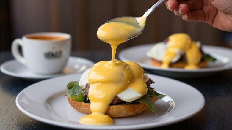 Pouring hollandaise sauce over egg on toast