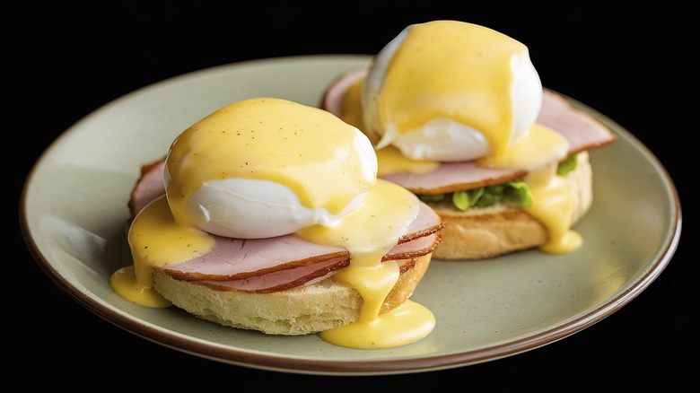 Eggs Benedict on a plate covered in hollandaise sauce