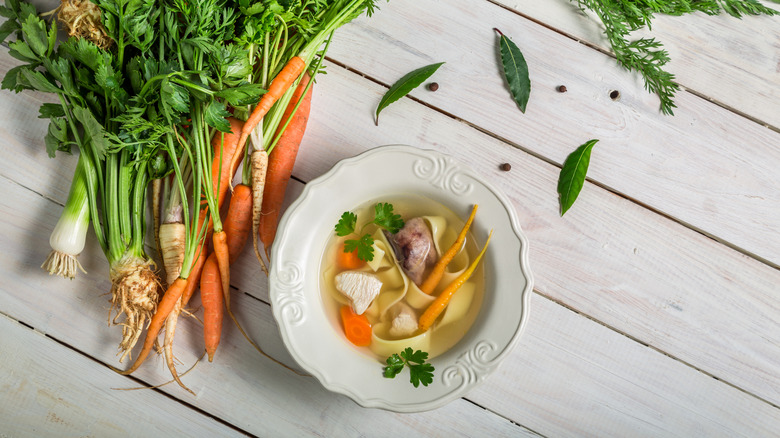 bowl of broth with noodles and veggies