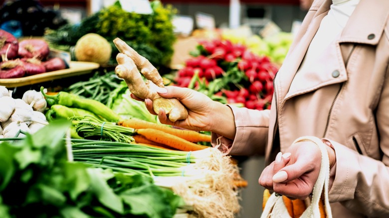 Person shopping for ginger in produce aisle