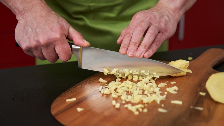 Person chopping ginger with a knife