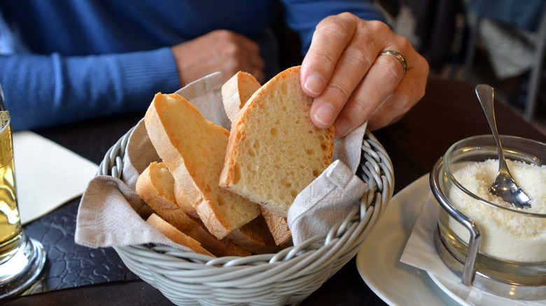 Hand grabbing bread from a basket. 