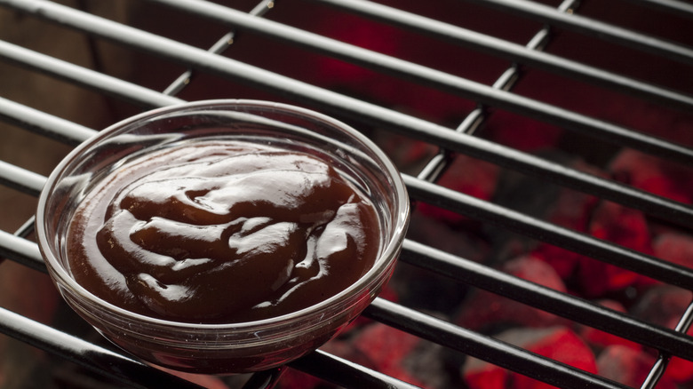 Bowl of BBQ sauce on grill grates