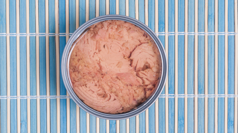 Can of tuna on wooden mat