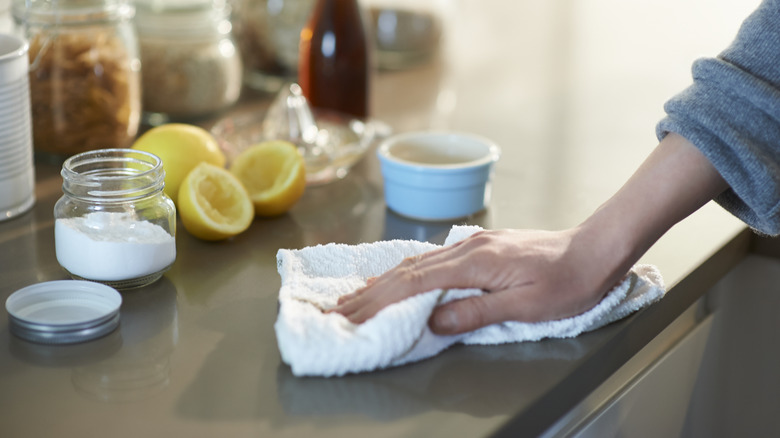 A person cleaning the kitchen using natural products like cornstarch and lemons