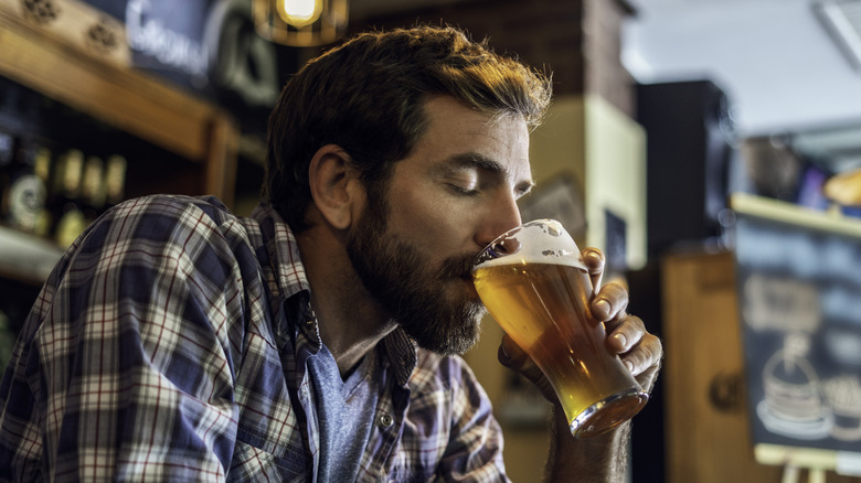 Person taking sip of beer