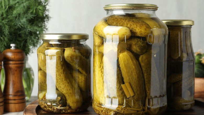 Jars of pickles sitting on a cutting board