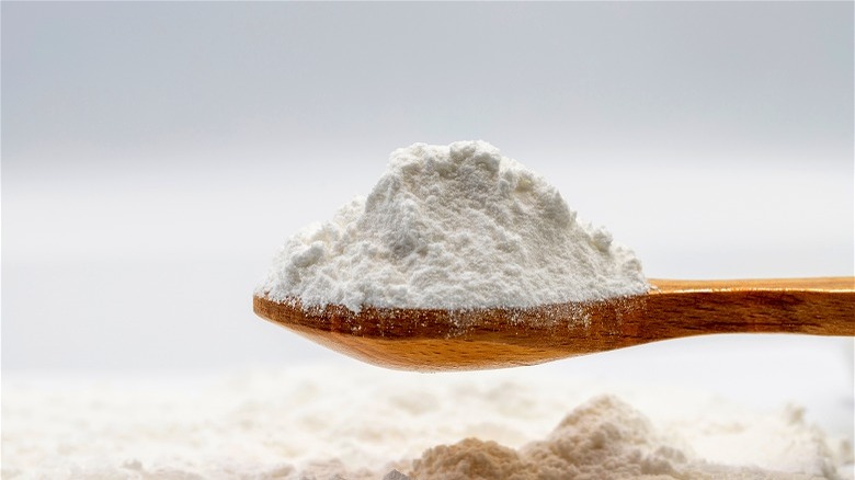 Flour with powdered sugar on a wooden spoon