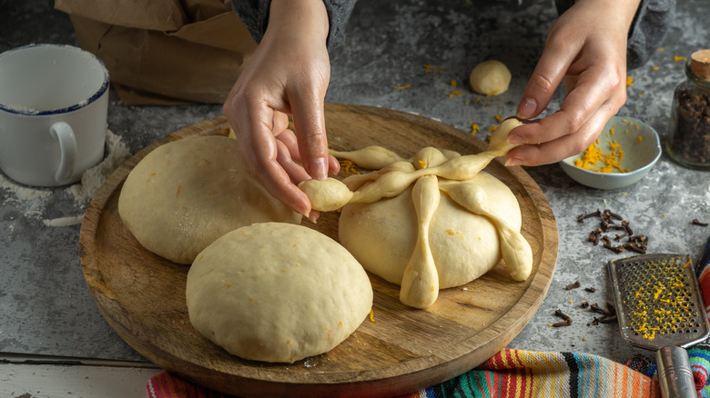 pan de muertos dough being decorated