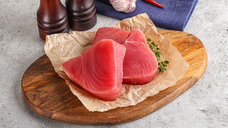 Raw tuna steaks on cutting board