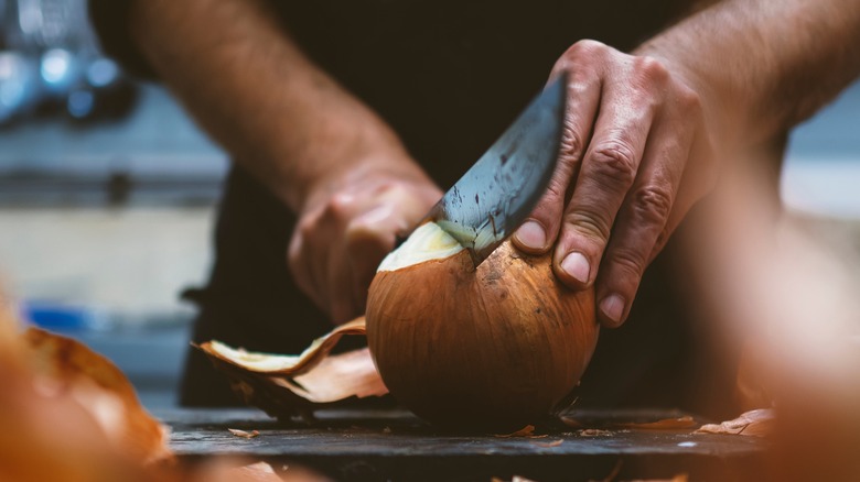 Cutting onion with peel on 