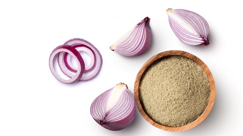 Sliced onions sitting next to onion powder