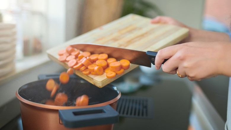 Scraping carrots into pot