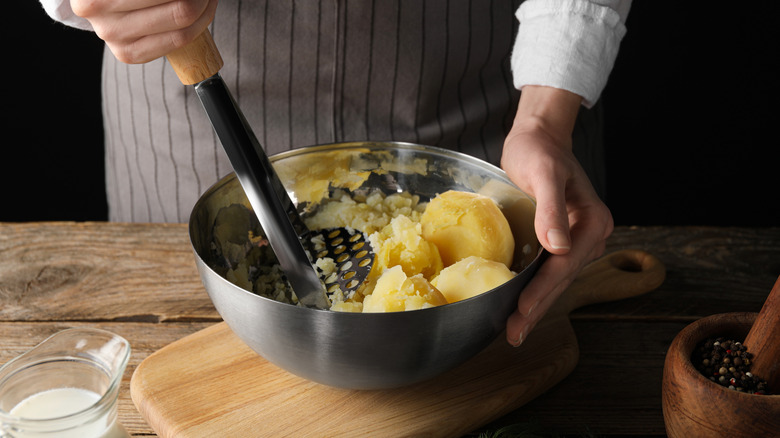 Woman mashing potatoes