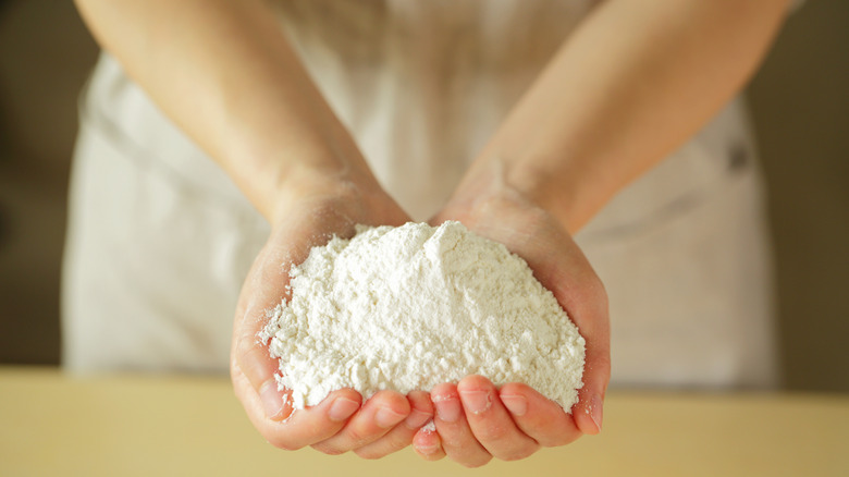 Person holding handful of flour