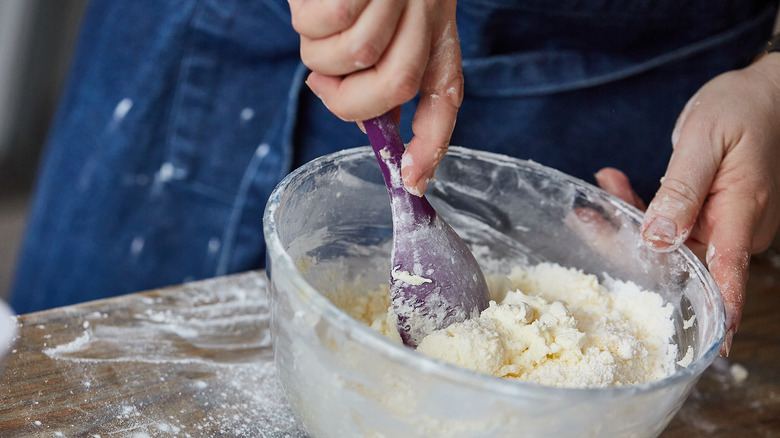 Hand mixing ingredients in a bowl