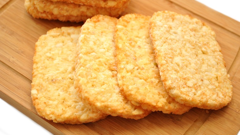 Hash brown patties on wooden cutting board