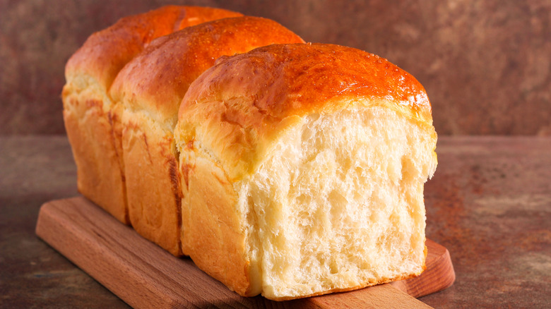 A loaf of Japanese milk bread on wooden board