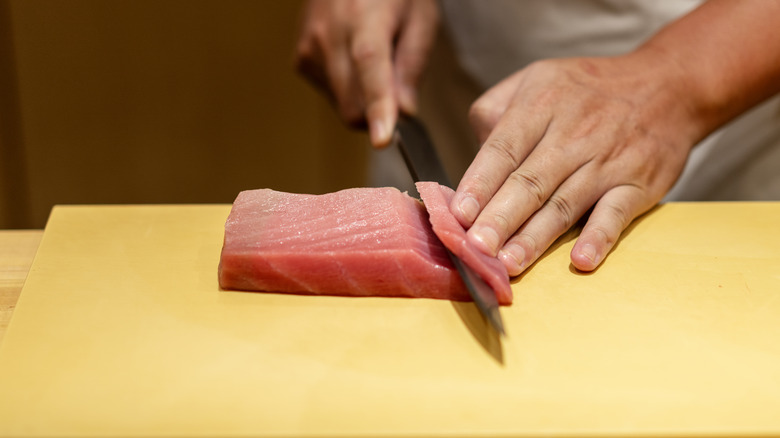 Cutting raw sushi fish at an angle