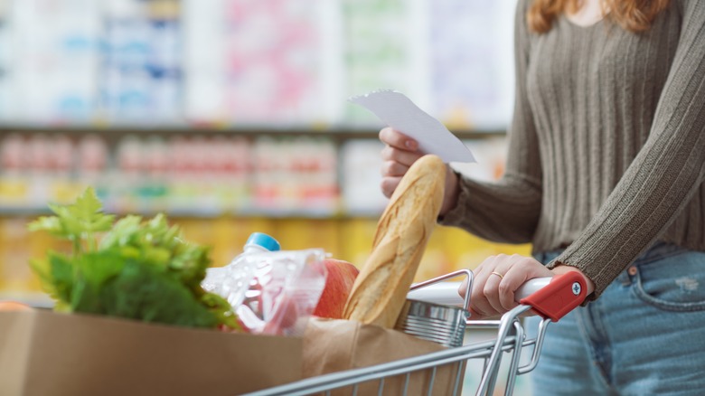 Person grocery shopping with a list