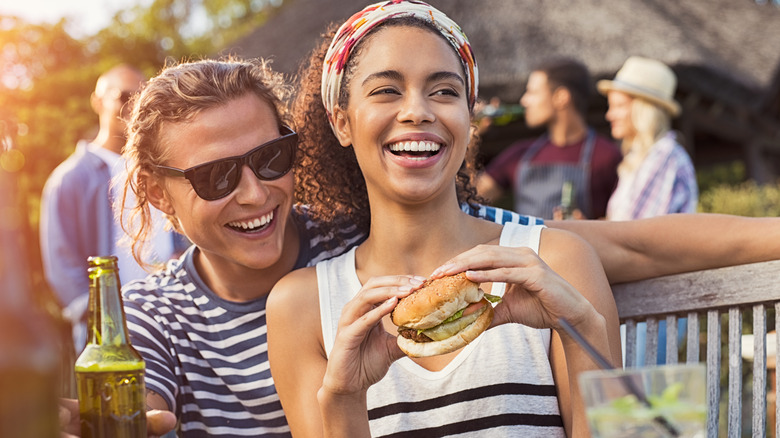 Woman smiling with a hamburger