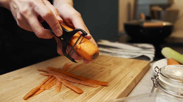 Hands peeling a carrot