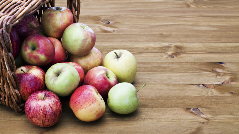 different apples on wooden table