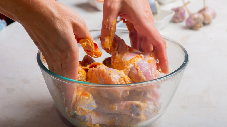 Tossing chicken in creamy marinade