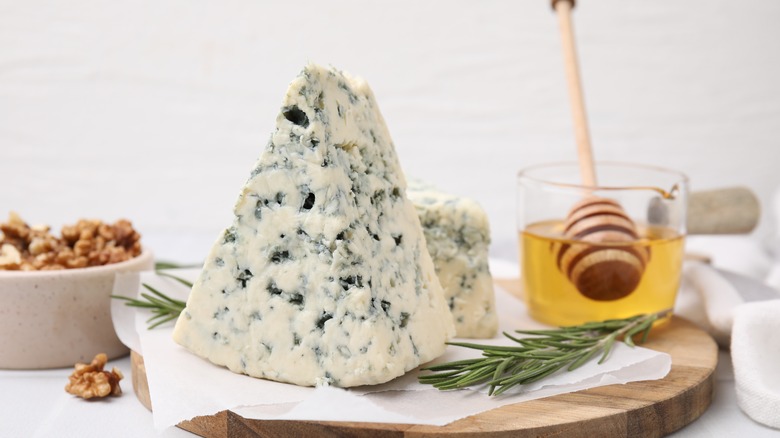 Blue cheese on a wooden board with honey and walnuts