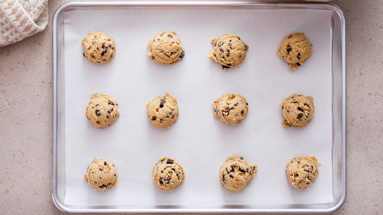 Scooped chocolate chip cookie dough on cookie pan