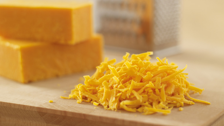 Shredded cheese on a cutting board