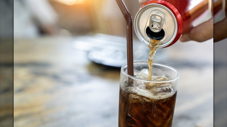 Pouring a can of cola into a glass