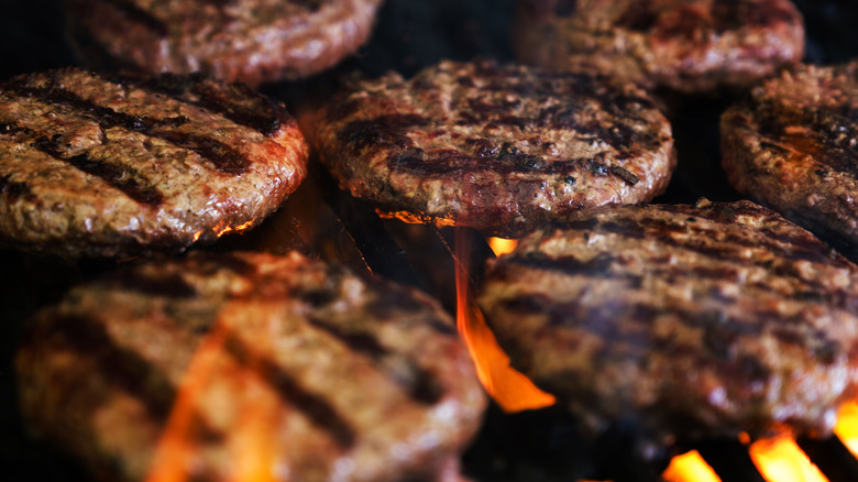 beef patties over fire on grill