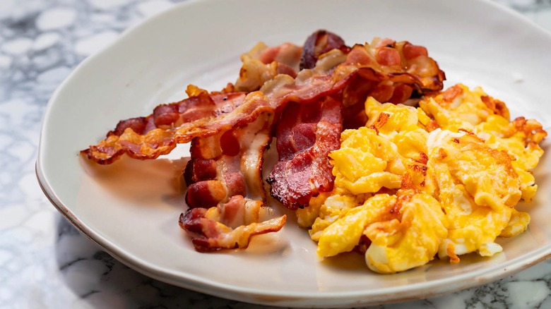 Bacon and eggs on a white plate