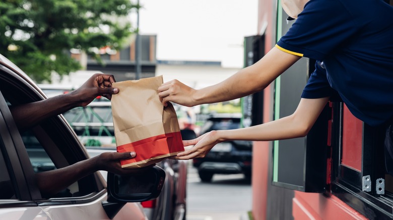 Bag being passed through a drive-thru window