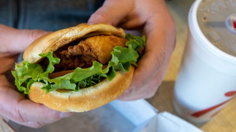 Hands holding Chick-fil-A sandwich