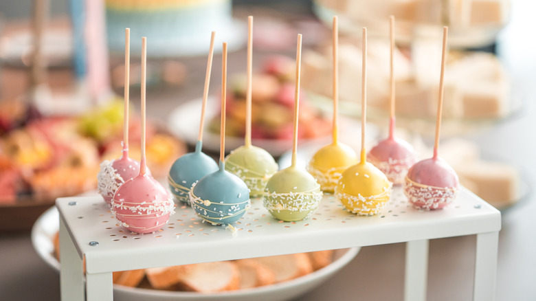 Pastel colored cake pops on white stand