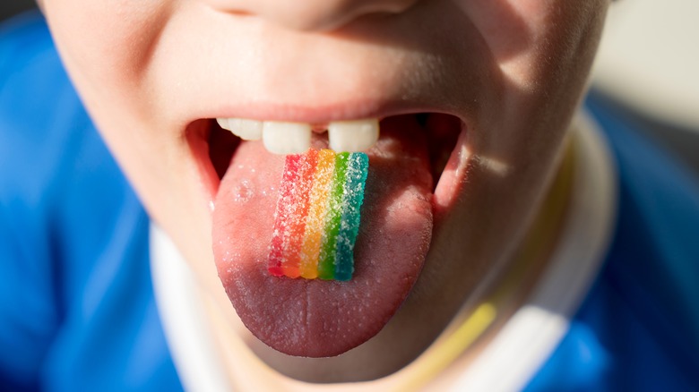 strip of sour candy on child's tongue