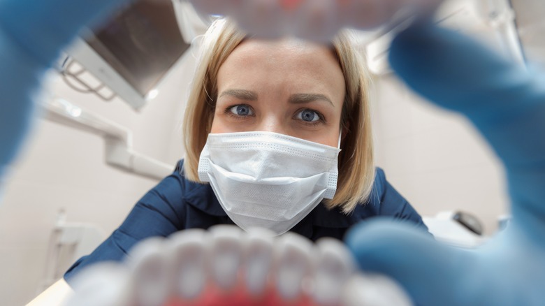 dentist looking inside a patient's mouth