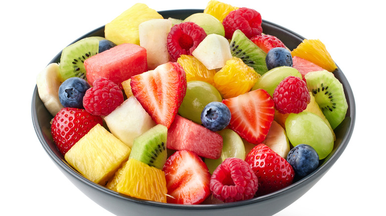 Bowl of fruit salad containing berries, pineapple, and melons