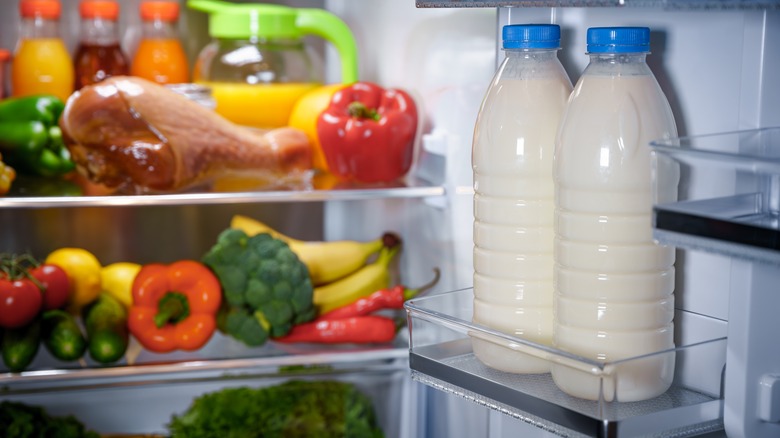 two bottles of milk sitting in fridge door