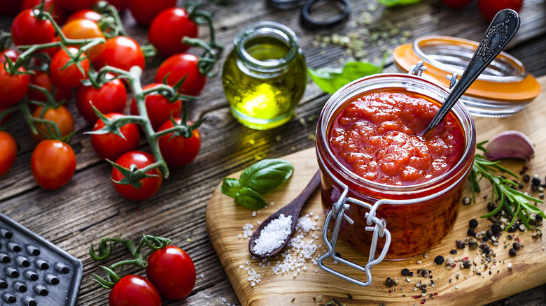 Jar of homemade marinara sauce with ingredients