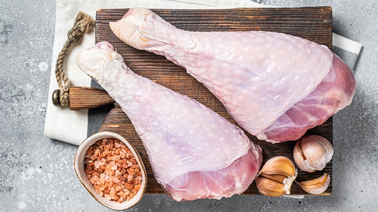 Raw turkey legs on a cutting board