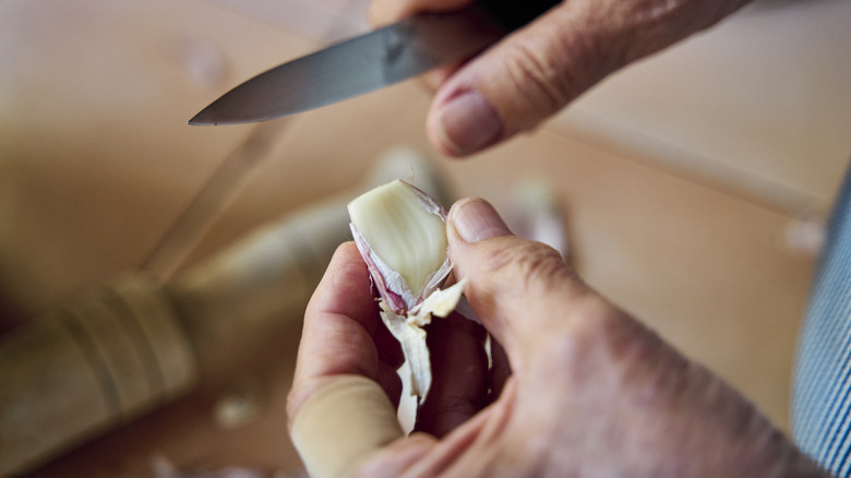 Peeling garlic cloves with a paring knife