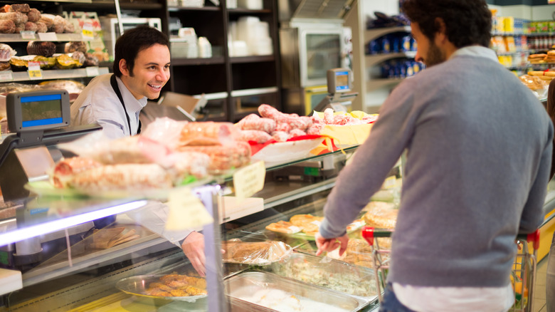 Deli counter clerk helping customer