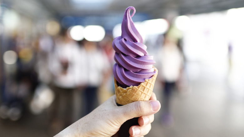 Hand holding cone of purple ice cream