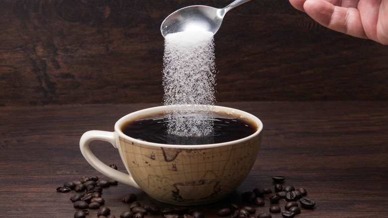 Pouring sugar into coffee