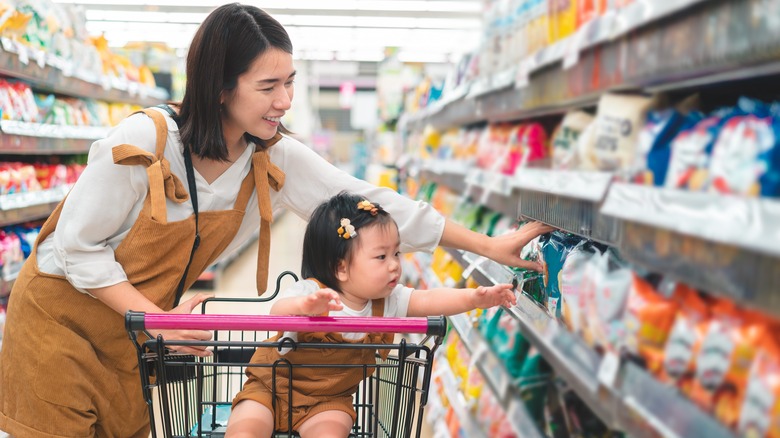 Parent and child reaching for shelved items